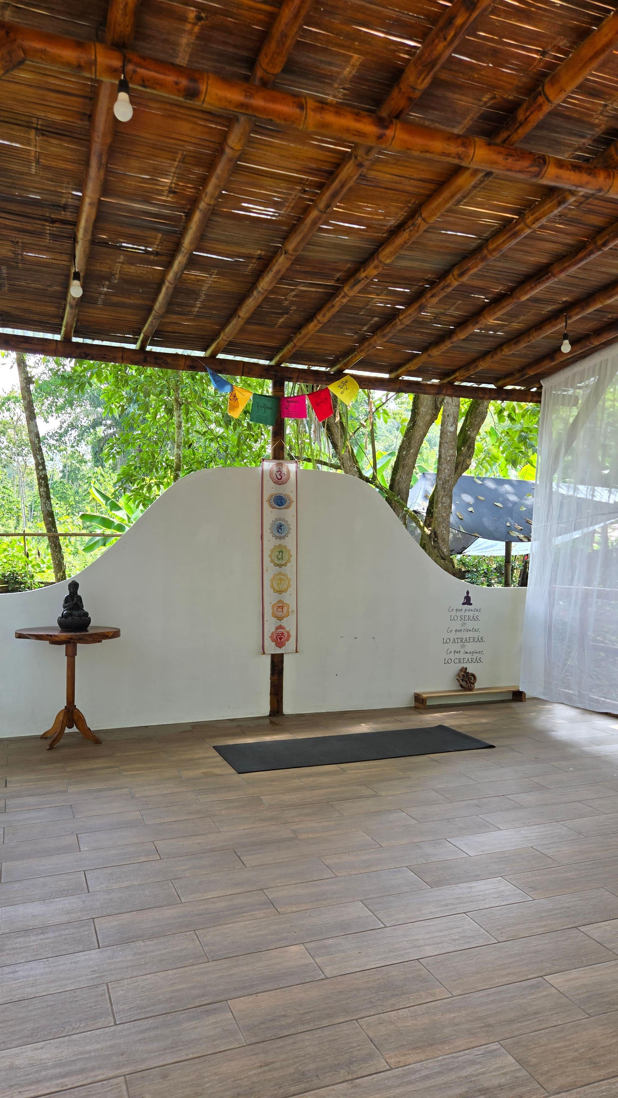 PlayaMagma's yoga shala, open to the forest, with a mat and a simple altar